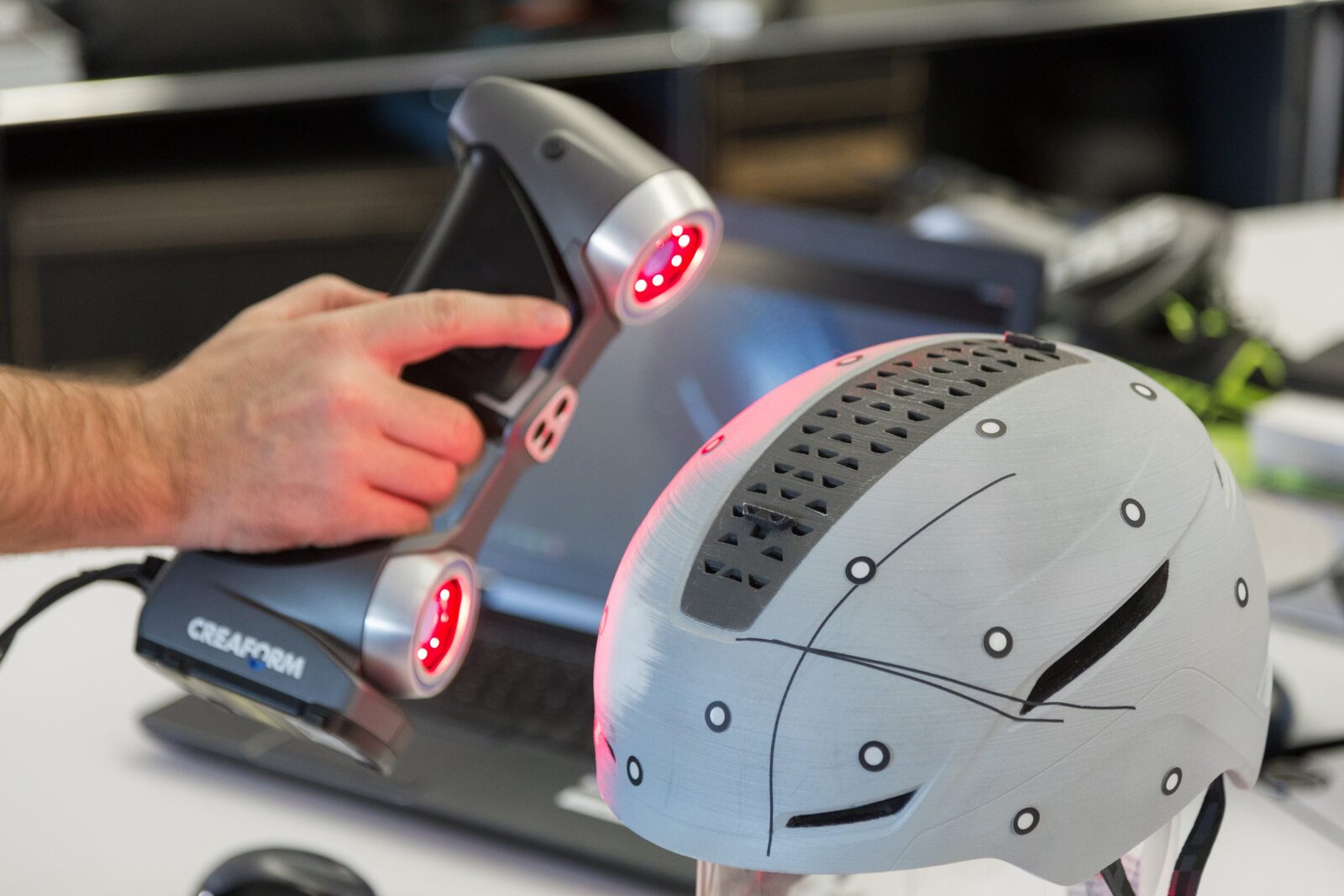 Handheld 3D scanner capturing a helmet with reference markers